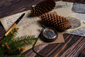 Vintage still life with pocket watch, pine cones, handwritten letter, and newspaper