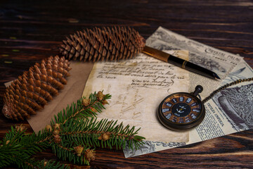 Vintage still life with pocket watch, pine cones, handwritten letter, and newspaper
