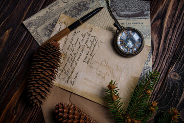 Vintage still life with pocket watch, pine cones, handwritten letter, and newspaper