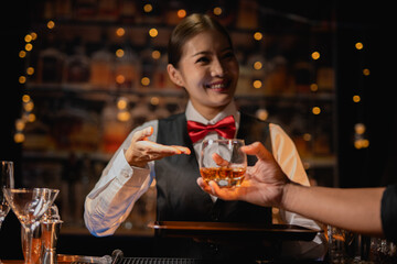 Professional female bartender preparing alcoholic drinks in a bar