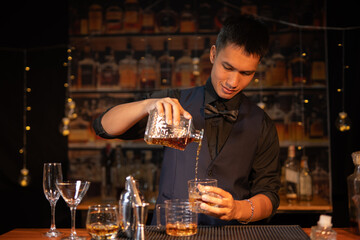 Professional male bartender preparing alcoholic drinks in a bar