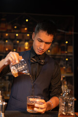 Professional male bartender preparing alcoholic drinks in a bar