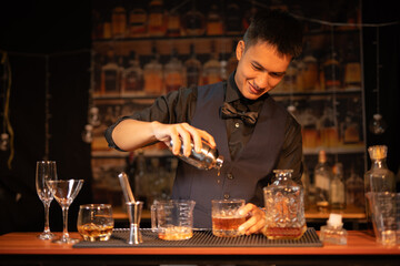 Professional male bartender preparing alcoholic drinks in a bar