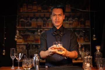 Professional male bartender preparing alcoholic drinks in a bar