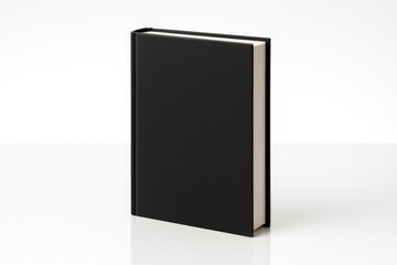 Dark hardcover book with black cover and glossy reflection on a white surface
