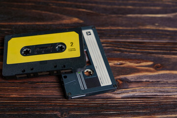 Two vintage audio cassette tapes on dark wooden surface