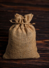 Burlap sack on dark wooden background with copy space