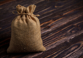 Burlap sack on dark wooden background with copy space