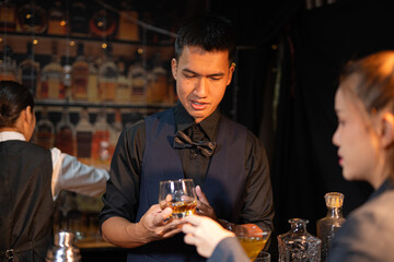 Professional male bartender preparing alcoholic drinks in a bar