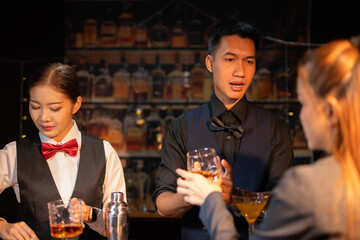 Professional female bartender preparing alcoholic drinks in a bar
