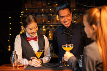 Professional female bartender preparing alcoholic drinks in a bar