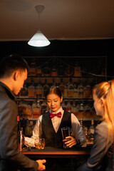 Professional female bartender preparing alcoholic drinks in a bar