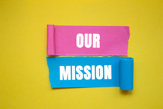 Our mission message written on ripped torn color paper pieces on yellow background. Conceptual our mission symbol. copy space.