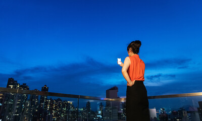 Young woman taking selfie on rooftop at night