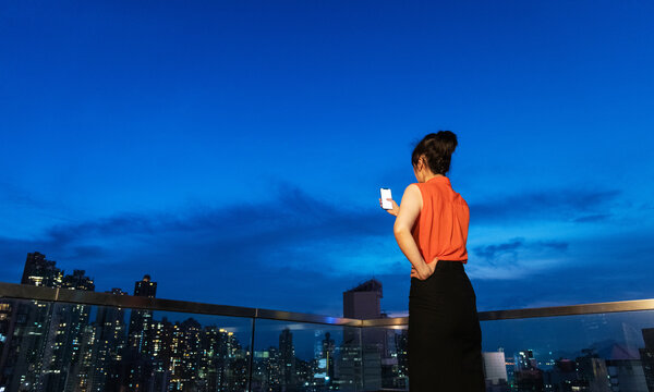 Young woman taking selfie on rooftop at night