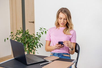 Woman texting on smartphone at home office