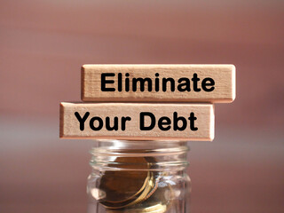 "Eliminate Your Debt" wording or text on wood block with coin in jar. Finance and  business concept.