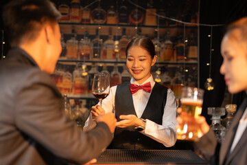 Professional female bartender preparing alcoholic drinks in a bar