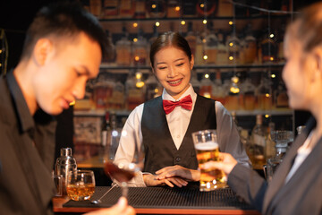 Professional female bartender preparing alcoholic drinks in a bar