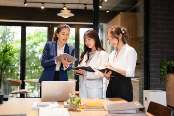 Focused female intern listening to senior  business woman mentor teacher explaining online strategy...