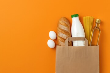 Obraz na płótnie Canvas Paper bag containing bread and milk with eggs, spaghetti, and olive oil on vibrant orange backdrop for quarantine food supplies.