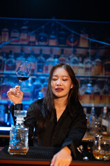 Beautiful young woman drinking alcohol at nightclub bar enjoying a pub party