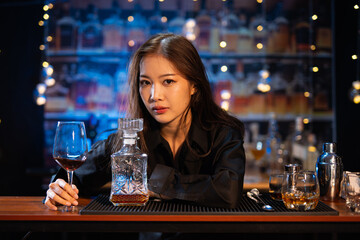Beautiful young woman drinking alcohol at nightclub bar enjoying a pub party