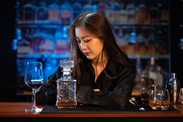 Beautiful young woman drinking alcohol at nightclub bar enjoying a pub party