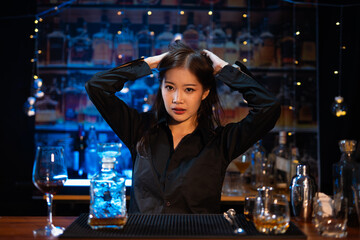 Beautiful young woman drinking alcohol at nightclub bar enjoying a pub party