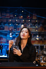 Beautiful young woman drinking alcohol at nightclub bar enjoying a pub party