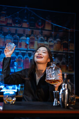 Beautiful young woman drinking alcohol at nightclub bar enjoying a pub party