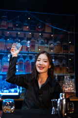 Beautiful young woman drinking alcohol at nightclub bar enjoying a pub party
