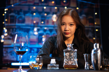 Beautiful young woman drinking alcohol at nightclub bar enjoying a pub party