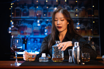 Beautiful young woman drinking alcohol at nightclub bar enjoying a pub party