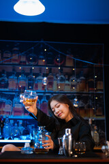 Beautiful young woman drinking alcohol at nightclub bar enjoying a pub party