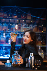 Beautiful young woman drinking alcohol at nightclub bar enjoying a pub party