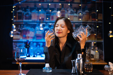 Beautiful young woman drinking alcohol at nightclub bar enjoying a pub party