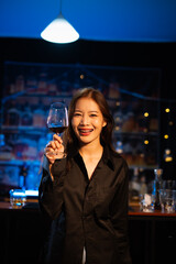 Beautiful young woman drinking alcohol at nightclub bar enjoying a pub party