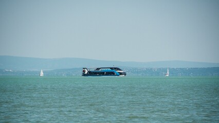 ferry sails across the blue surface of Lake Ballaton in Hungary