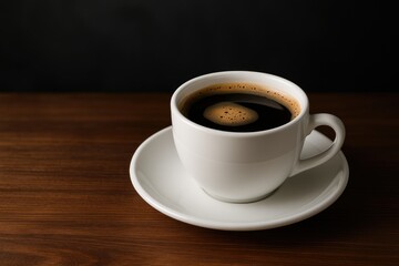 A mug of coffee resting on a surface against a dark backdrop