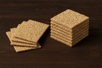 Low-calorie grain crackers displayed on a dark wooden surface