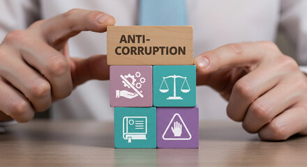 Person holding wooden blocks with anti corruption symbols and text representing law justice and ethics