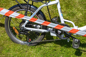The scene of a bicycle accident surrounded by red and white warning tape, a cyclist's accident,