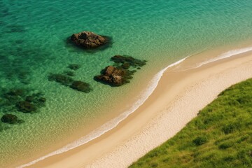Aerial perspective of a shoreline featuring rocky formations and clear emerald waters