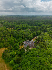 An aerial view of a historic mansion surrounded by lush green trees and a beautifully landscaped...