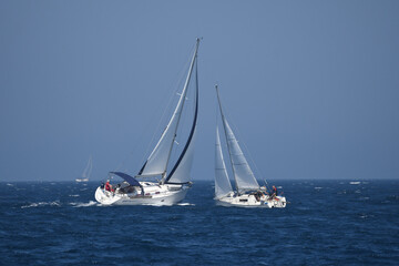 Sailing Adventure on a Clear Blue Sea: Two Yachts Compete in a Regatta
