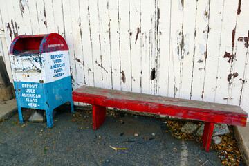 Vintage Deposit Box for Used American Flag beside an Old American Wooden House