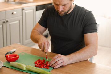 Man preparing fresh vegetables in modern kitchen, organic ingredients. Healthy meal. Cooking Food...