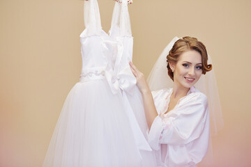 A bride is posing with a white dress and veil