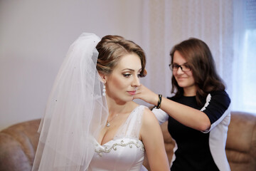 A woman is getting her hair done by another woman